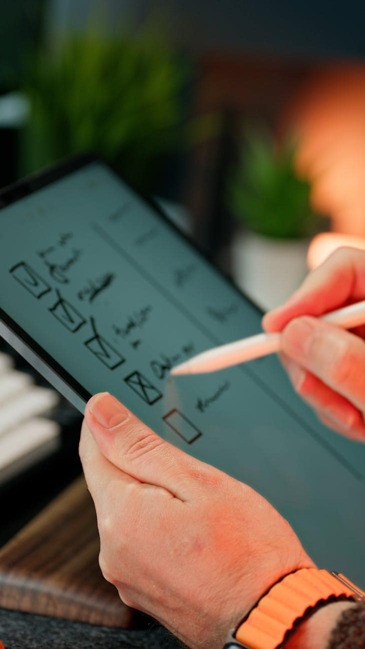 hands writing on digital checklist with stylus