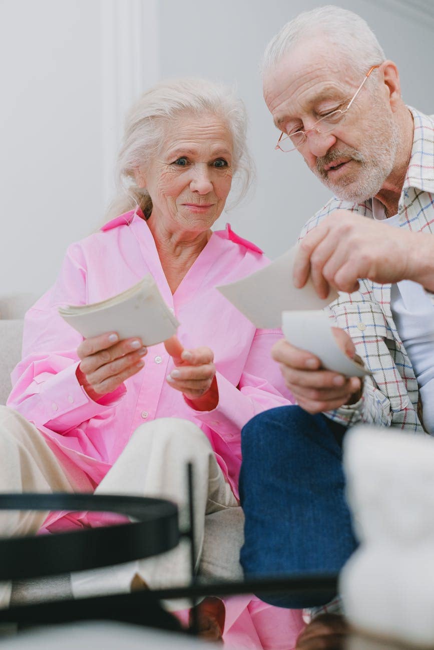 an elderly couple looking at photographs